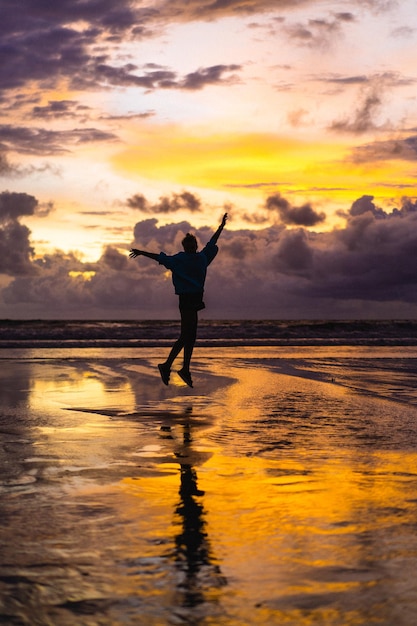 Hermosa joven al atardecer en el océano, Bali, Indonesia.