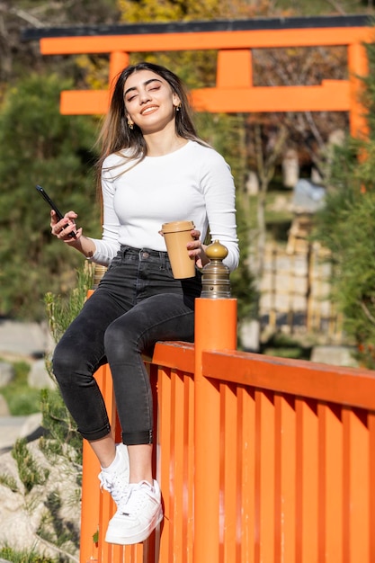 Una hermosa joven alegre con una taza de café Foto de alta calidad