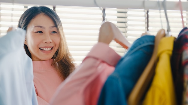 Foto gratuita hermosa joven atractiva eligiendo su ropa de moda en el armario de la casa o tienda.