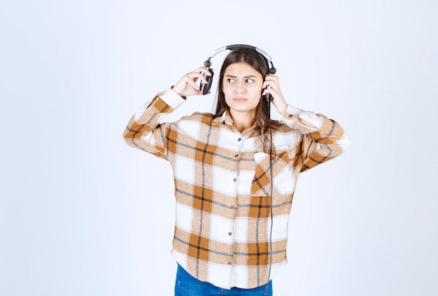 Foto gratuita hermosa joven en auriculares tratando de alejarse de la música.