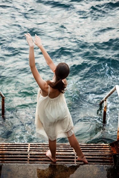 Hermosa joven bailarina bailando y posando fuera del fondo del mar