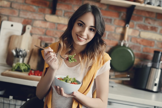 Hermosa joven comiendo una ensalada saludable