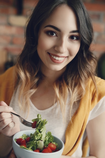 Foto gratuita hermosa joven comiendo una ensalada saludable