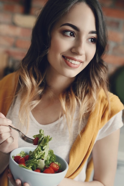 Hermosa joven comiendo una ensalada saludable