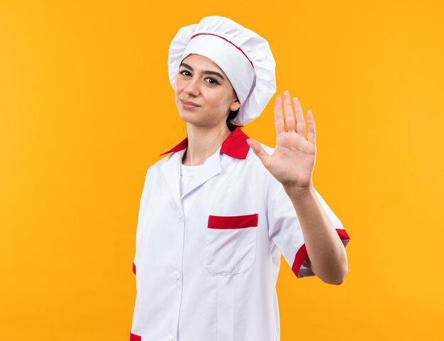 Hermosa joven disgustada en uniforme de chef mostrando gesto de parada