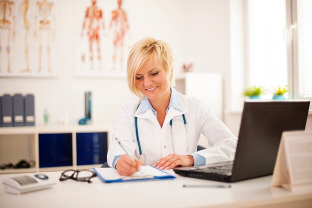 Hermosa joven doctora trabajando en su oficina