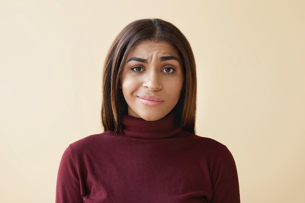 Hermosa joven empleada afroamericana con cabello lacio oscuro que tiene una mirada disgustada y se siente frustrada y estresada mientras tiene problemas y fracasos en el trabajo.