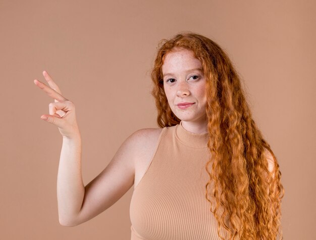 Hermosa joven enseñando lenguaje de señas
