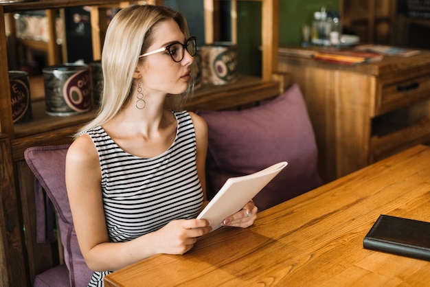 Hermosa joven esperando el orden en el restaurante