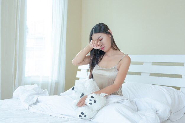 Una hermosa joven está durmiendo y un despertador en el dormitorio de su casa.