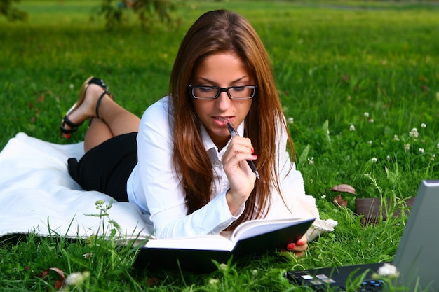 Hermosa joven estudiando en el parque