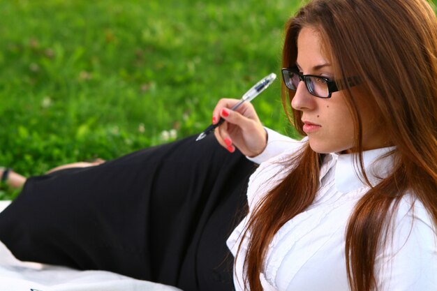 Hermosa joven estudiando en el parque