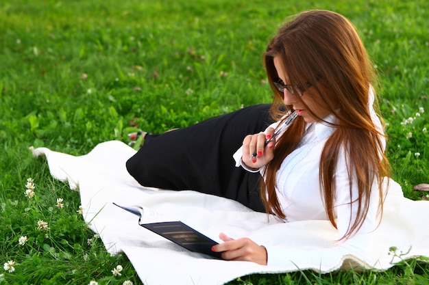 Hermosa joven estudiando en el parque