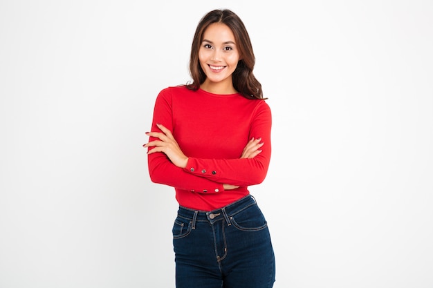 Hermosa joven feliz de pie con los brazos cruzados