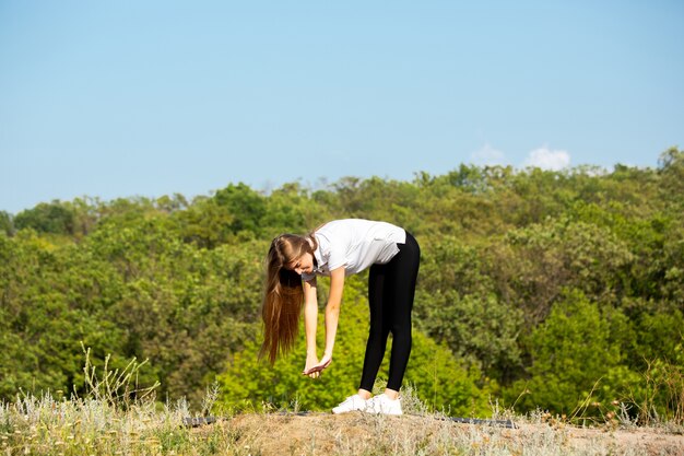 Hermosa joven flexibilidad de formación al aire libre