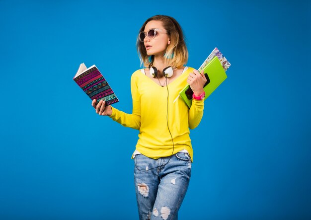 Hermosa joven hipster mujer sosteniendo libros