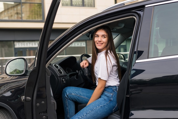 Hermosa joven con llave de coche en mano