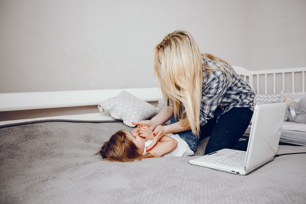 Una hermosa joven madre con su pequeña hija jugando en casa