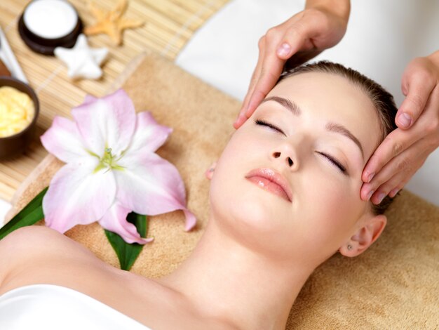 Hermosa joven con masaje spa de la cabeza en salón de belleza - en el interior