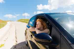 Foto gratuita hermosa joven mirando por la ventana del coche