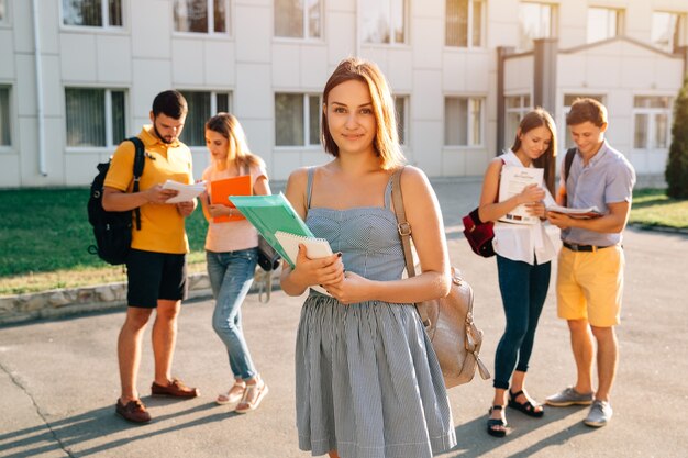 Hermosa joven con mochila de terciopelo rojo con libros