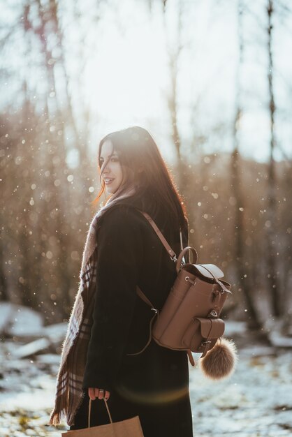 Hermosa joven modelo posando en bosque de invierno