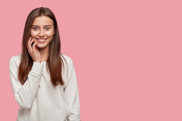 Foto gratuita hermosa joven morena con apariencia agradable, tierna sonrisa