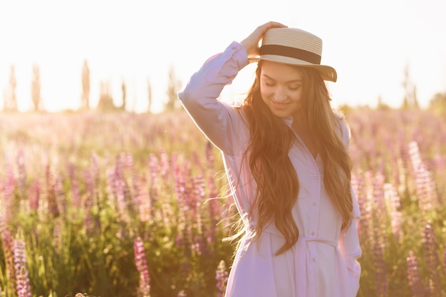 Foto gratuita una hermosa joven morena. atractiva chica sexy en un campo con flores