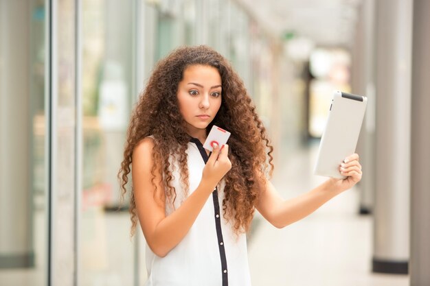 Hermosa joven pagando con tarjeta de crédito para ir de compras