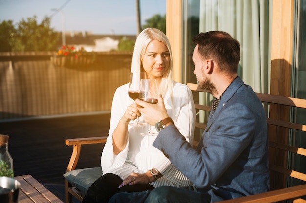 Hermosa joven pareja brindando copas de vino