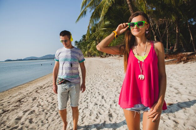 Hermosa joven pareja caminando en la playa tropical, Tailandia, salón de vacaciones, atuendo hipster, estilo casual, luna de miel, vacaciones, verano, estado de ánimo soleado y romántico