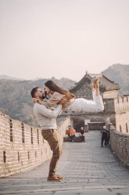 Hermosa joven pareja corriendo y saltando en la Gran Muralla de China.