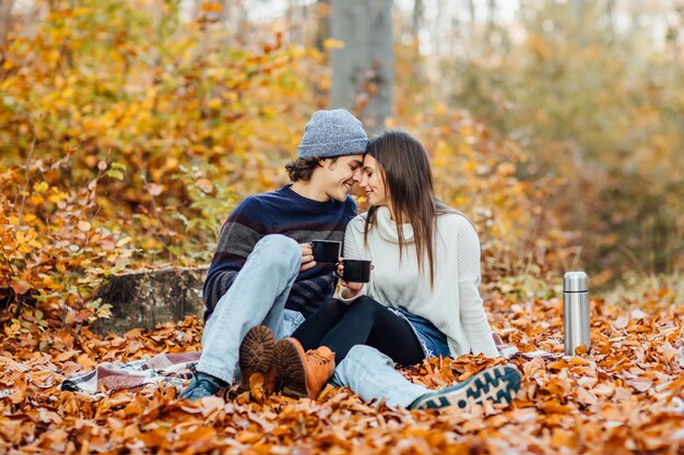 Hermosa joven pareja disfrutando de un picnic en el bosque