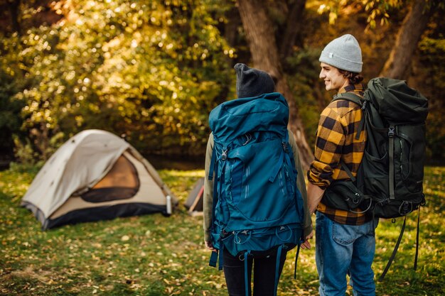 Hermosa joven pareja con mochilas de senderismo ir de trekking