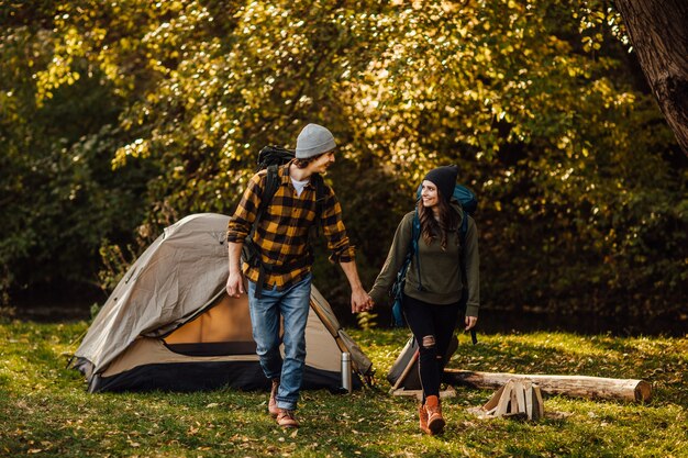 Hermosa joven pareja con mochilas de senderismo ir de trekking