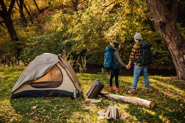 Hermosa joven pareja con mochilas de senderismo ir de trekking