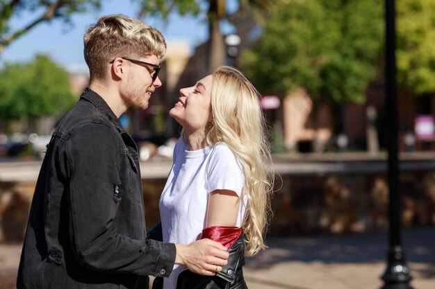 Hermosa joven pareja de pie y sonriendo el uno al otro Foto de alta calidad