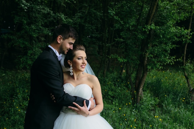 Hermosa joven pareja posando en el bosque desde un ángulo cercano