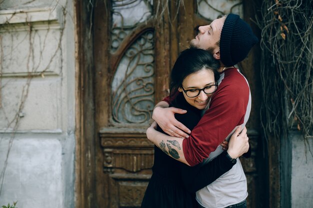 Hermosa joven pareja posando sobre un edificio antiguo