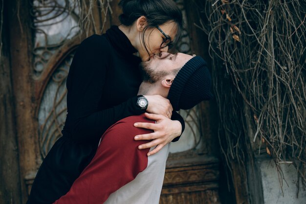 Hermosa joven pareja posando sobre un edificio antiguo