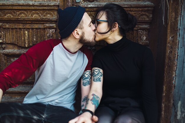 Hermosa joven pareja posando sobre un edificio antiguo