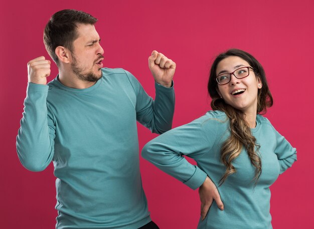 Hermosa joven pareja en ropa casual azul hombre y mujer feliz y emocionado divirtiéndose feliz en el amor juntos