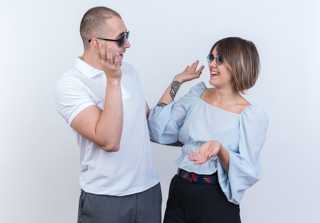 Hermosa joven pareja en ropa casual hombre y mujer mirando el uno al otro feliz y alegre teniendo cinco de pie