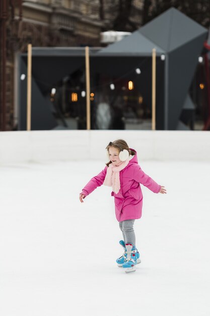 Hermosa joven patinaje sobre hielo