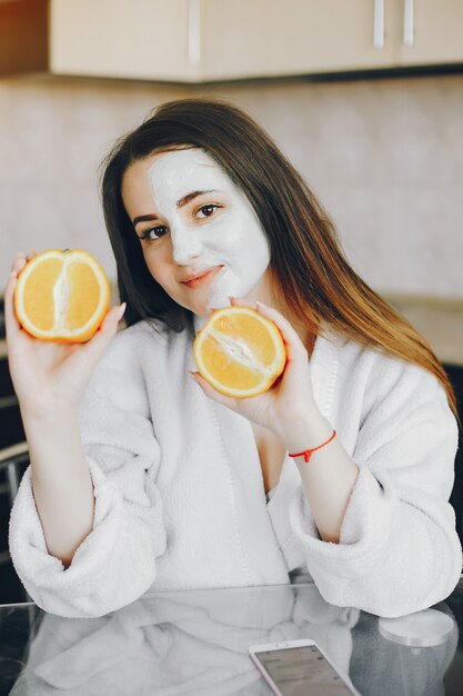 hermosa joven con pelo largo y túnica blanca con una máscara en la cara sentado en casa