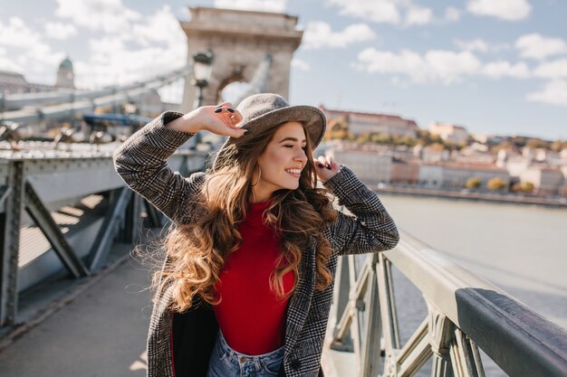 Hermosa joven posando con entusiasmo durante un viaje por Europa