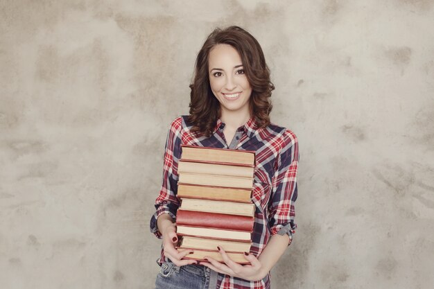 Hermosa joven posando con libros