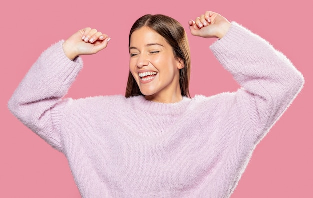 Foto gratuita hermosa joven posando con papel tapiz rosa en la espalda