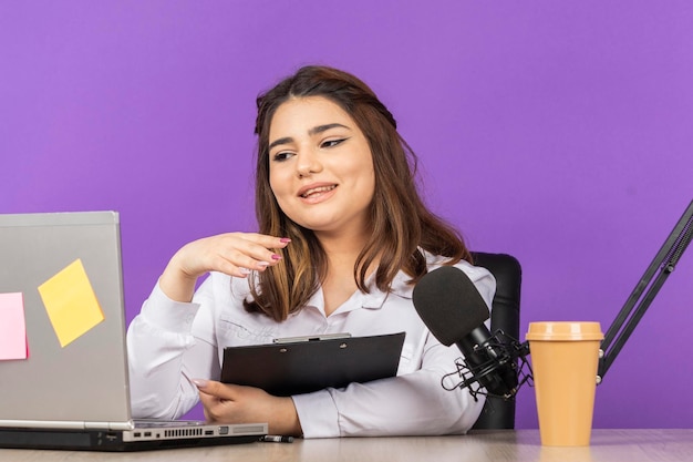 Hermosa joven presentadora de radio trabajando en pc Foto de alta calidad