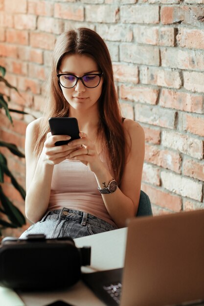 Hermosa joven con smartphone en casa